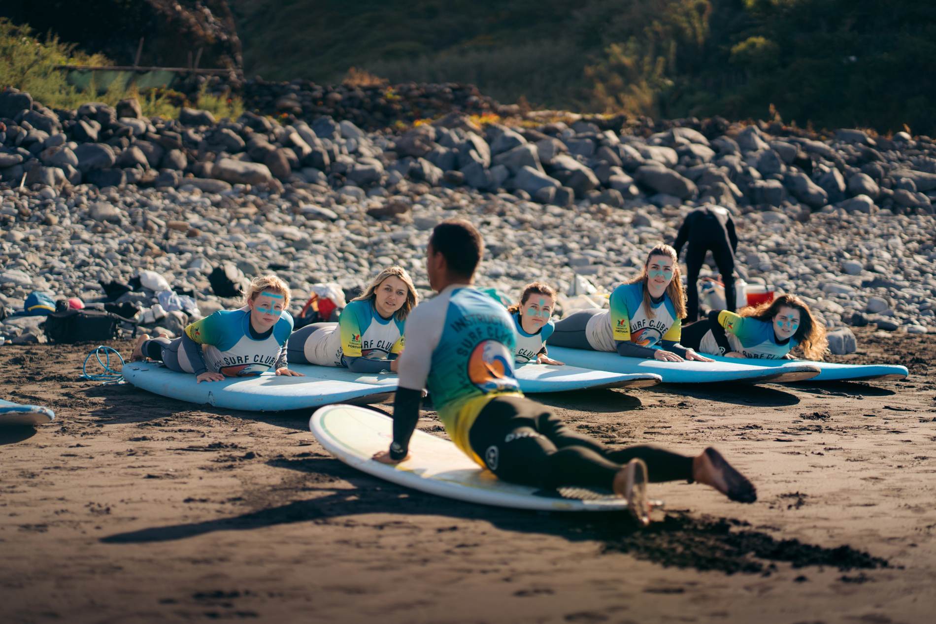 Aula de surf do Surf Clube da Madeira: alunos a praticar na praia com o instrutor